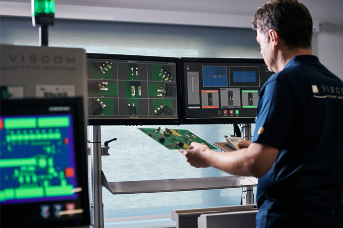 A man sitting in front of the Viscom software manually analyses the authenticity of the faulty products.